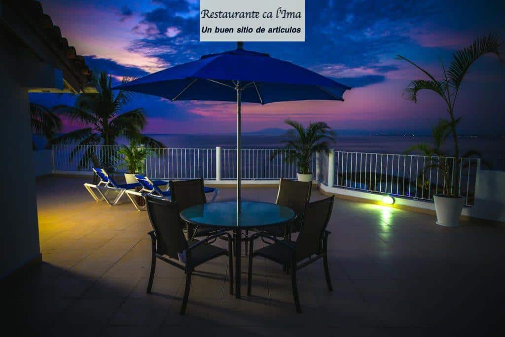 Stunning ocean view from a resort terrace at sunset with tropical plants and seating.