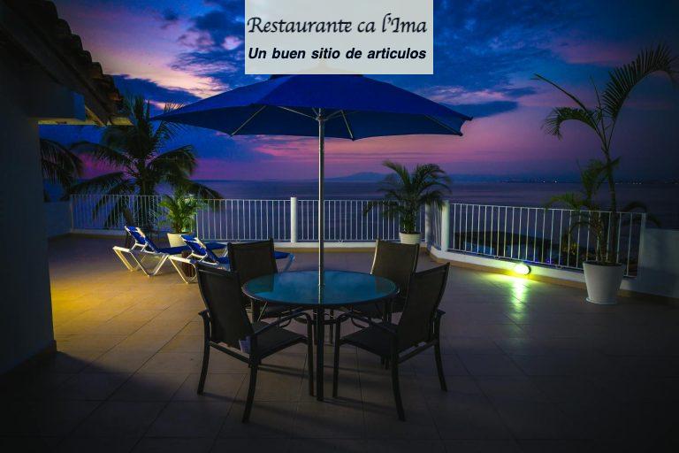 Stunning ocean view from a resort terrace at sunset with tropical plants and seating.