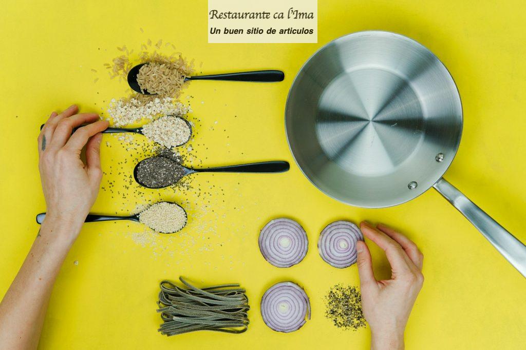 flat lay photography of saute skillet beside spoon of spices and vegetables